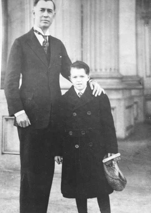 Boy standing with Uncle in front of 1930's home